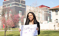 Photo of a girl holding a Thank You sign. Link to Gifts That Pay You Income.